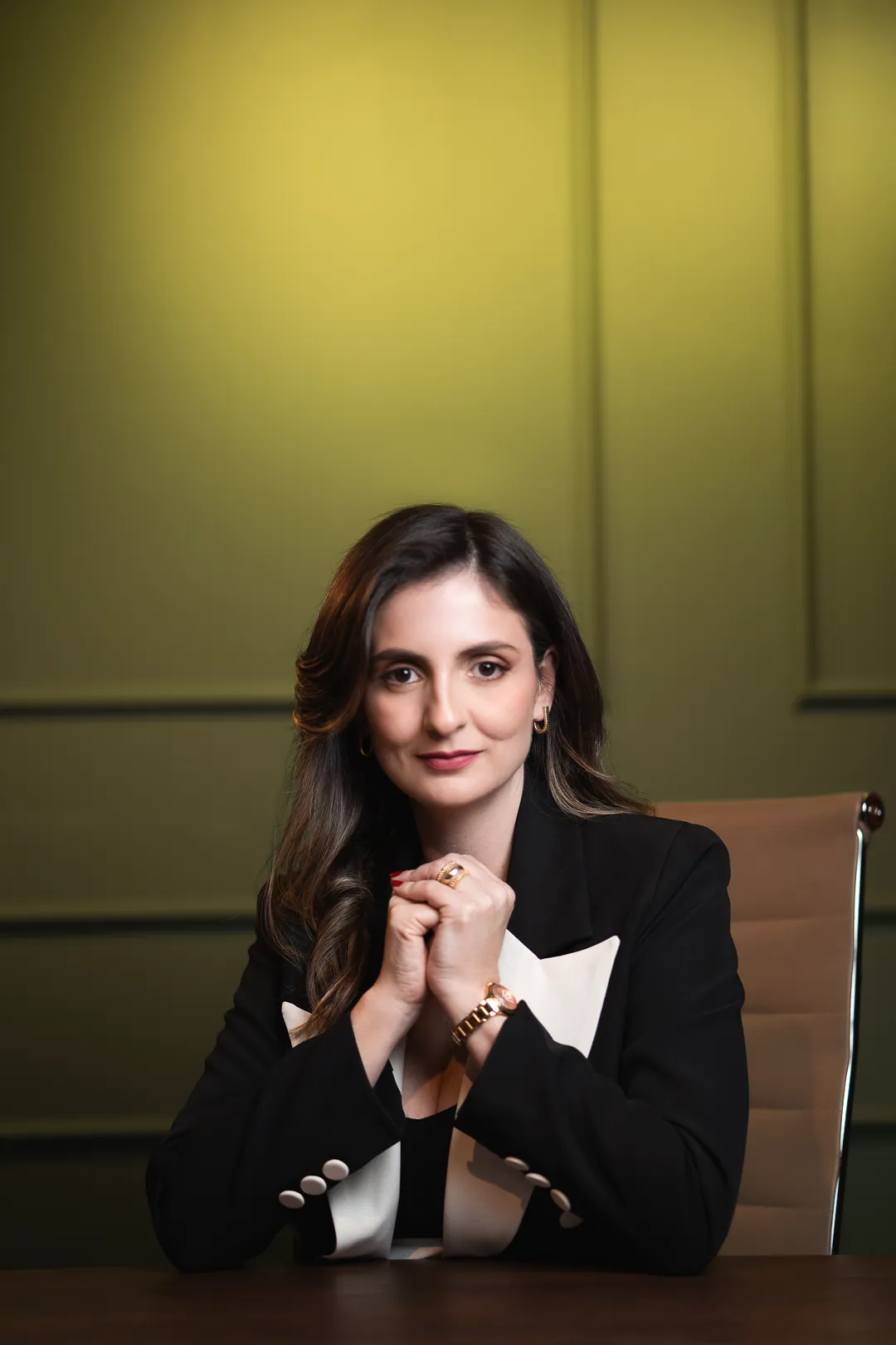 Dra. Danielle Nolêto sentada à mesa, com as mãos entrelaçadas